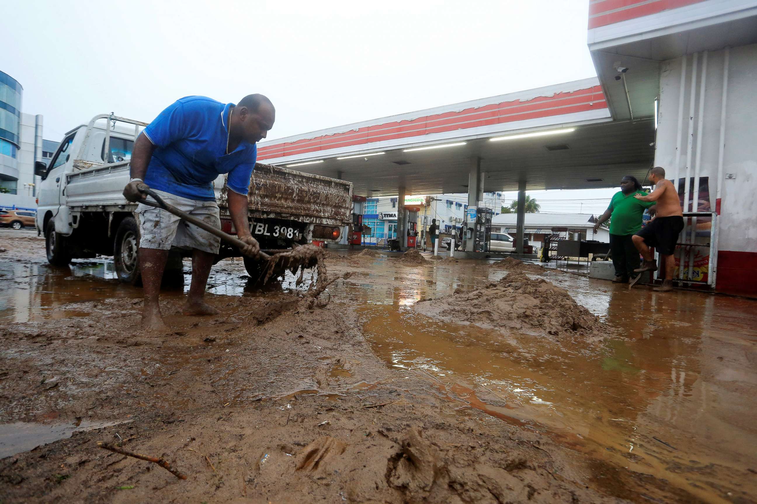 PHOTO: Residents remove mud from a gas station during a rain storm caused by Tropical Storm Karen in Barataria, Trinidad and Tobago, Sept. 22, 2019. 