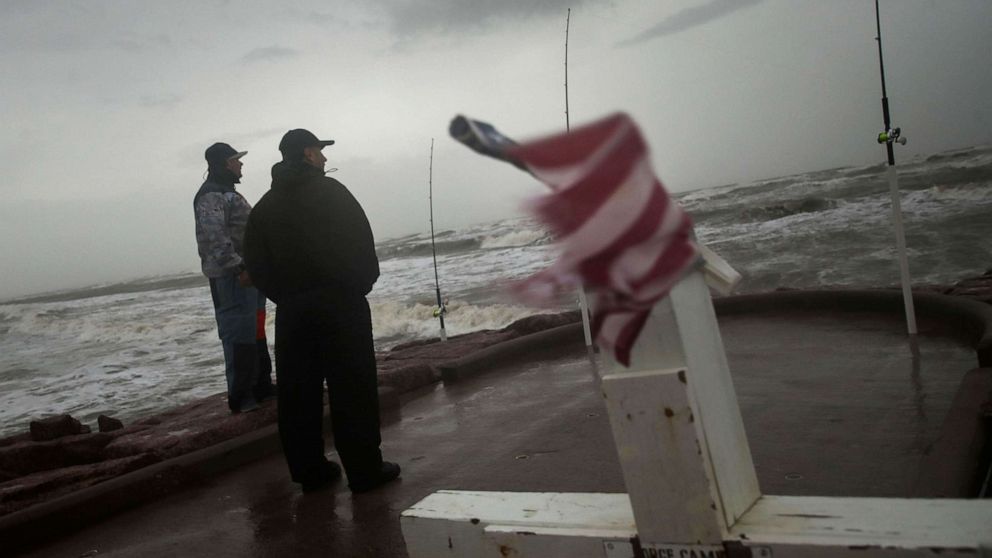 PHOTO: Jaime Ybarra and Frank Rivera, right, watch the wind and waves as Tropical Storm Nicholas heads toward the Texas coast, Sept. 13, 2021, along the seawall in Galveston, Texas.