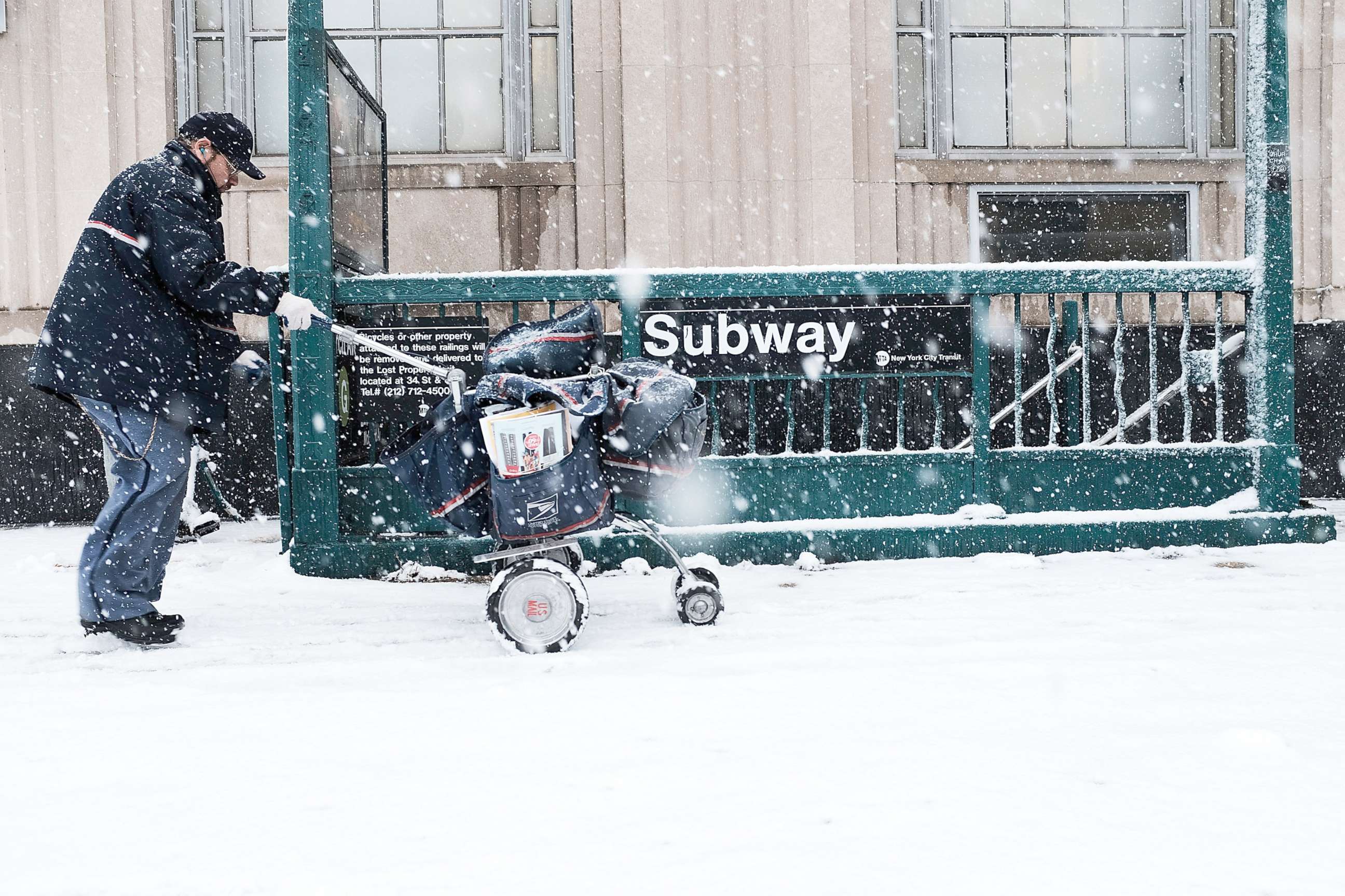 PHOTO: A mail carrier walks through the snow, March 21, 2018, in the Brooklyn borough of New York City. 