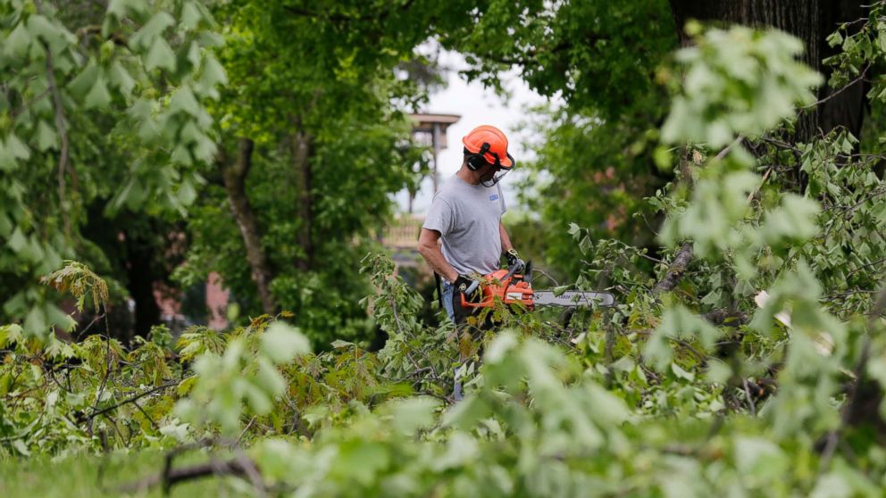 A man clears downed branches and debris on the grounds of Washington's Headquarters State Historic Site in Newburgh, N.Y., May 16, 2018.