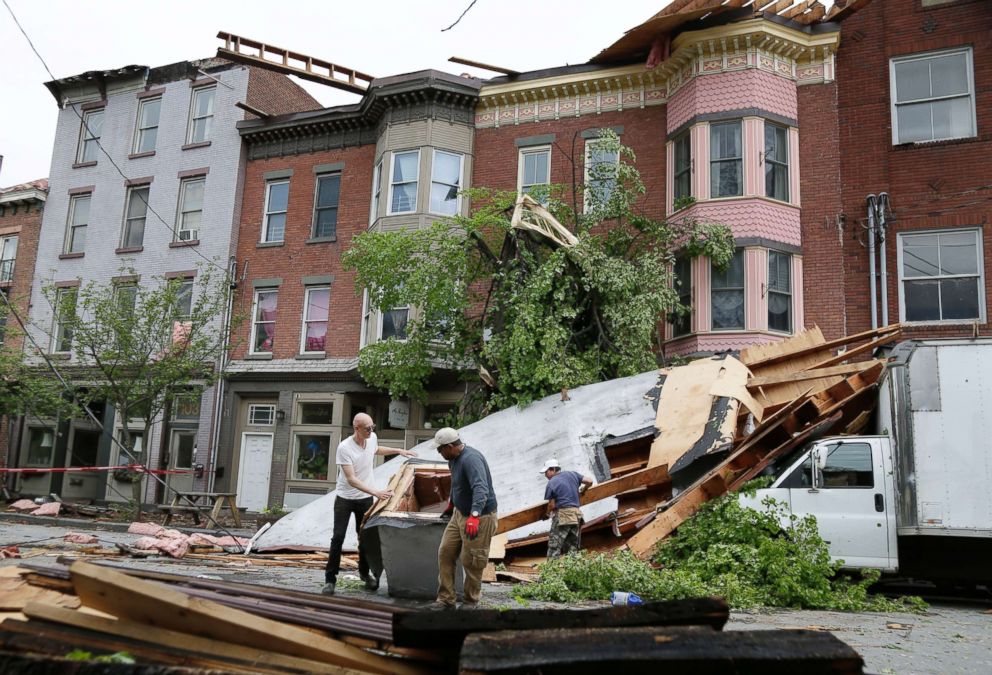 PHOTO: Men work to clear debris out of the street in Newburgh, N.Y., May 16, 2018.