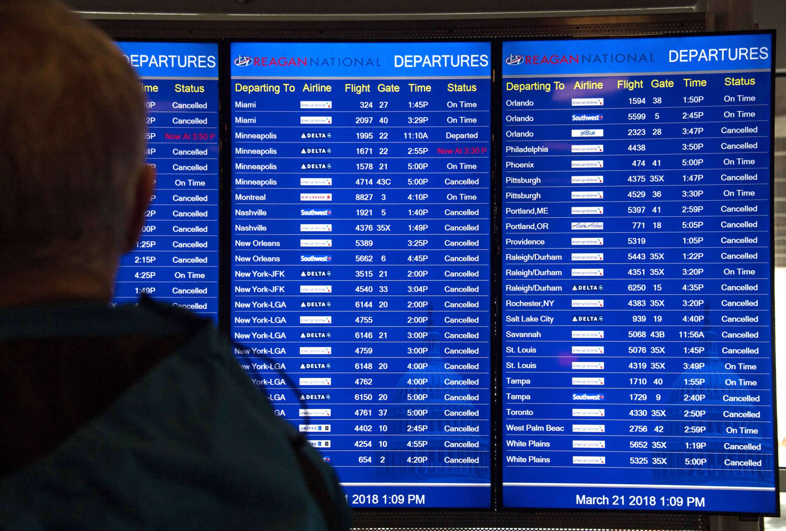 PHOTO: A person looks at a board showing many cancelled flights at Reagan National Airport in Arlington, Va., March 21, 2018, as heavy snow hit the northeastern U.S.