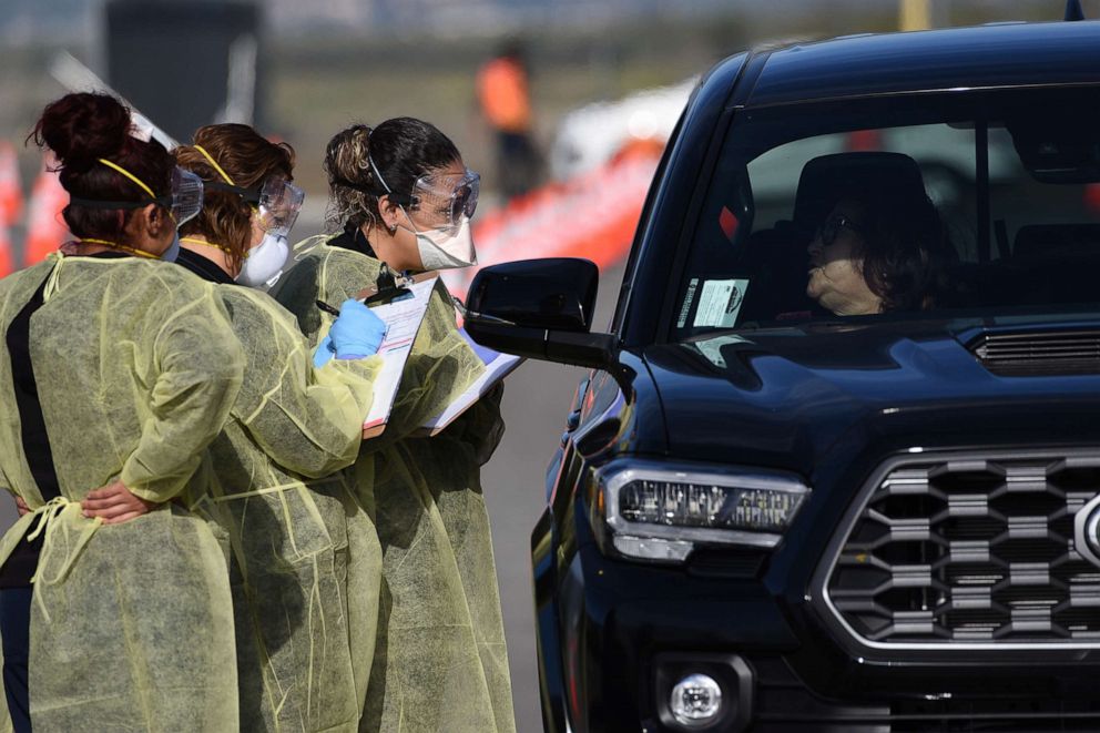 PHOTO: Medical personnel from Riverside (CA) University Health Systems hospitals administer a Coronavirus Test to an individual during drive-through testing in the parking lot of Diamond Stadium, March 22, 2020 in Lake Elsinore, Calif. 