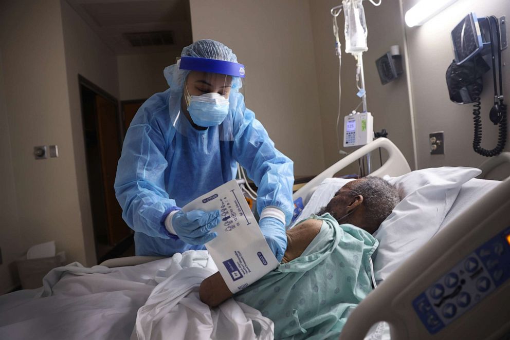 PHOTO: Kennedy Rutland gets vital information from a COVID-19 patient at Roseland Community Hospital, Dec. 17, 2020, in Chicago.