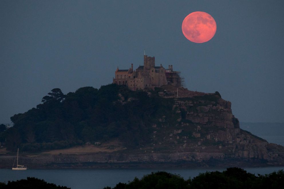 PHOTO: In this June 28, 2018, file photo, a strawberry moon rises behind St Michael's Mount in Mount's Bay, Cornwall, England.