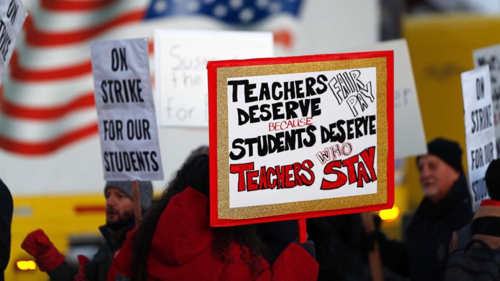 PHOTO: Teachers carry placards as they walk a picket line outside South High School,, Feb. 11, 2019, in Denver.