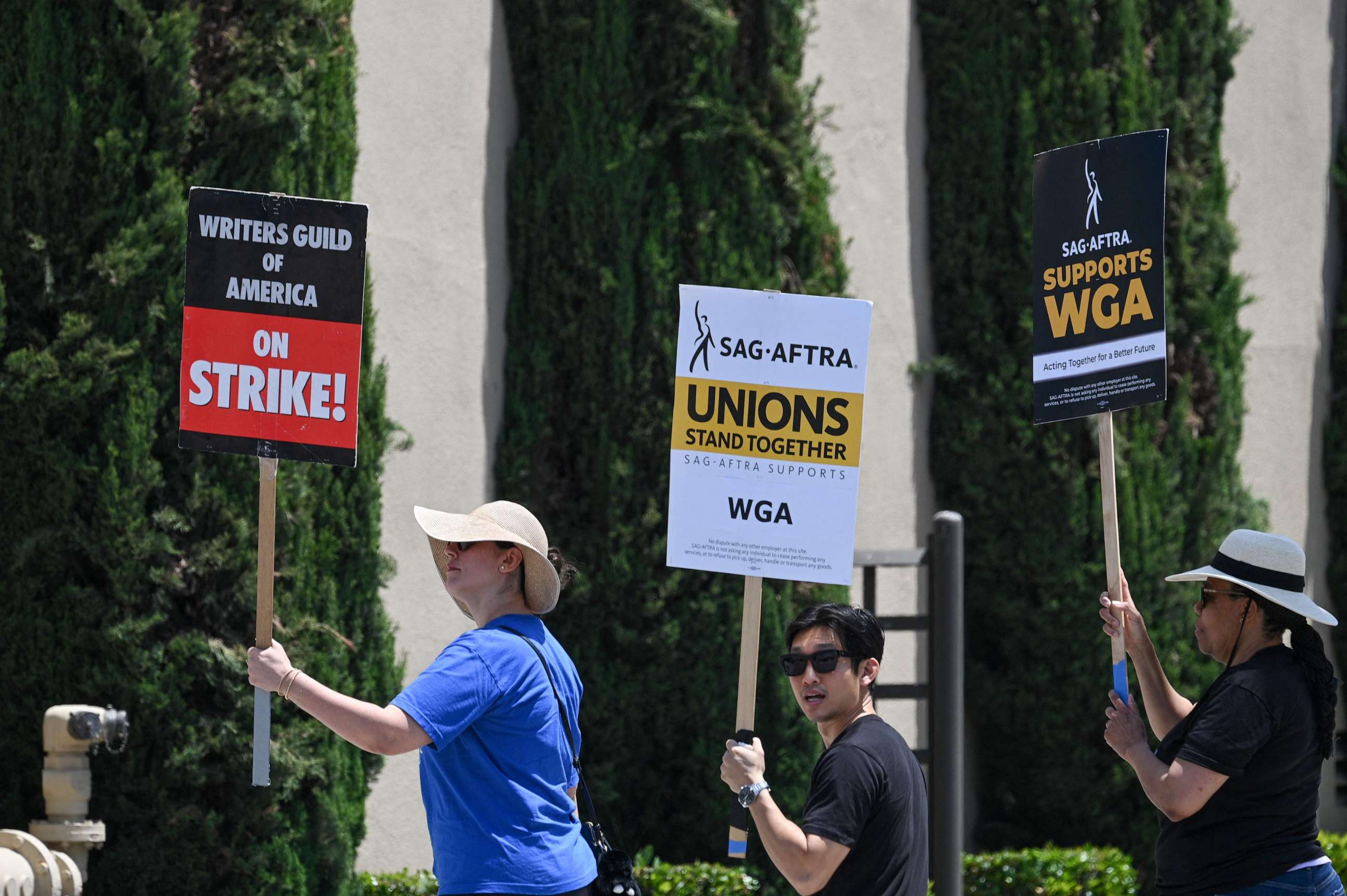 PHOTO: Hollywood writers and their supporters from the SAG AFTRA actors' union walk the picket line outside Warner Bros Studios in Burbank, California, June 30, 2023. (Photo by Robyn Beck / AFP) (Photo by ROBYN BECK/AFP via Getty Images)