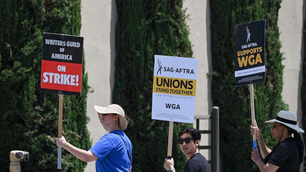 PHOTO: Hollywood writers and their supporters from the SAG AFTRA actors' union walk the picket line outside Warner Bros Studios in Burbank, California, June 30, 2023. (Photo by Robyn Beck / AFP) (Photo by ROBYN BECK/AFP via Getty Images)