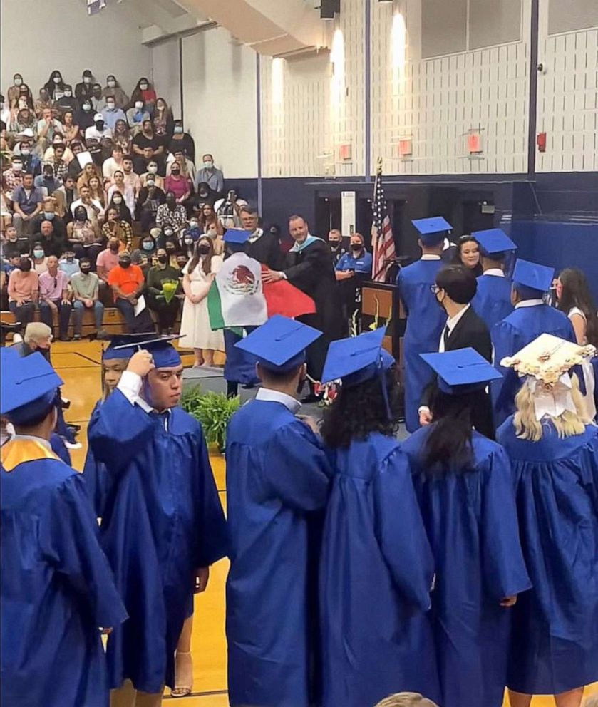 PHOTO: A student wearing a Mexican flag over his graduation gown at his graduation ceremony walks away after receiving his diploma holder in an image taken from video provided by graduation attendee Adolfo Hurtado.