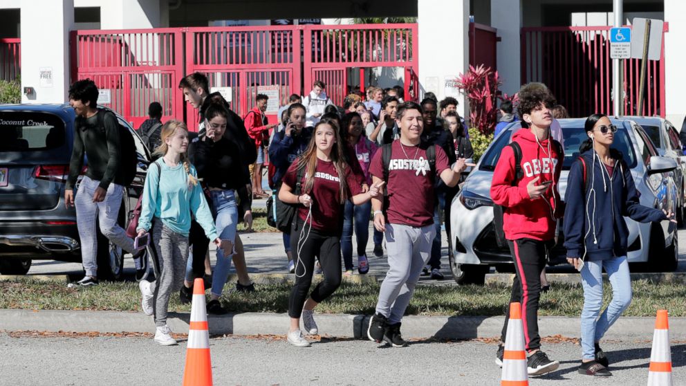 Students walk out of Marjory Stoneman Douglas High School, as part of a nationwide protest against gun violence, March 14, 2018, in Parkland, Fla.