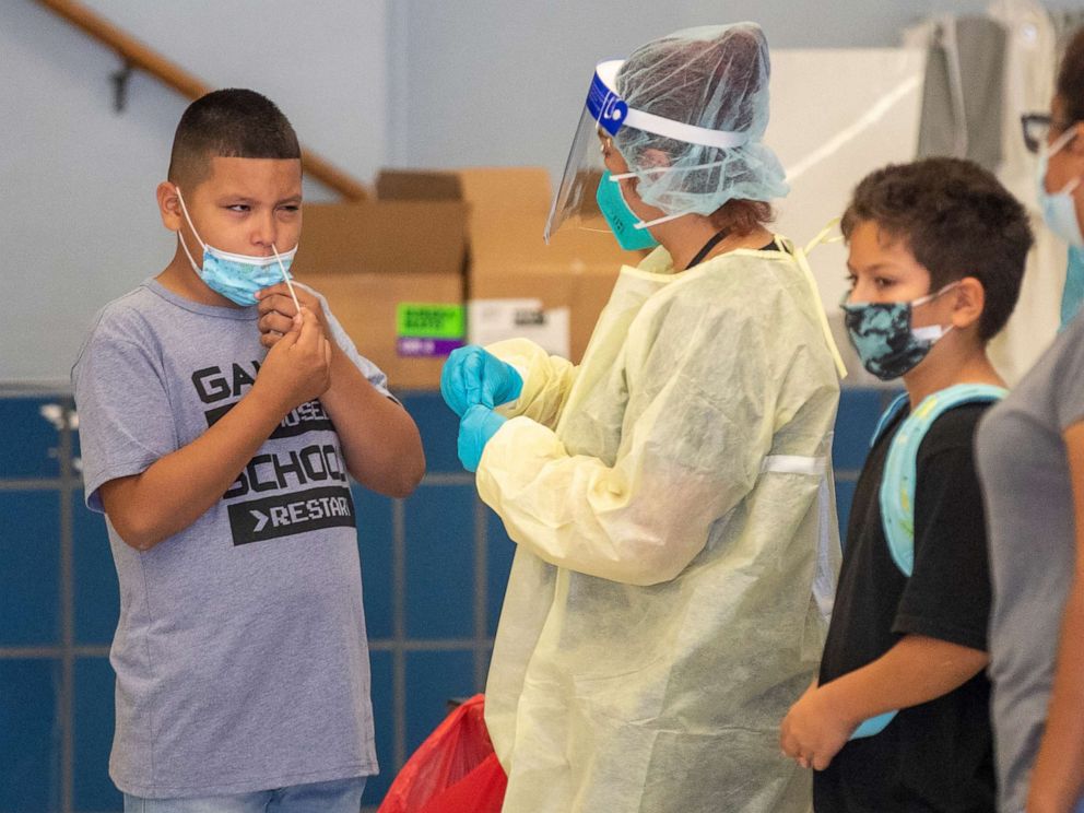 PHOTO: A medical professional oversees as a fifth-grader gives himself a weekly rapid COVID-19 test on the first day of school at Los Angeles Unified School District at Montara Avenue Elementary School, Aug. 16, 2021, in South Gate, Calif.