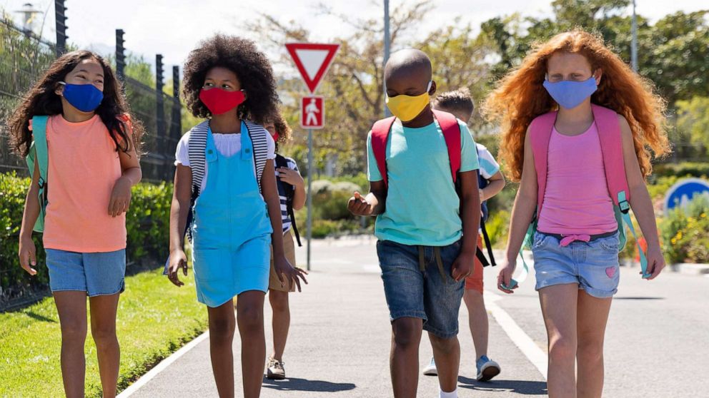 PHOTO: School children wearing face masks are pictured walking on the street in this undated stock image.