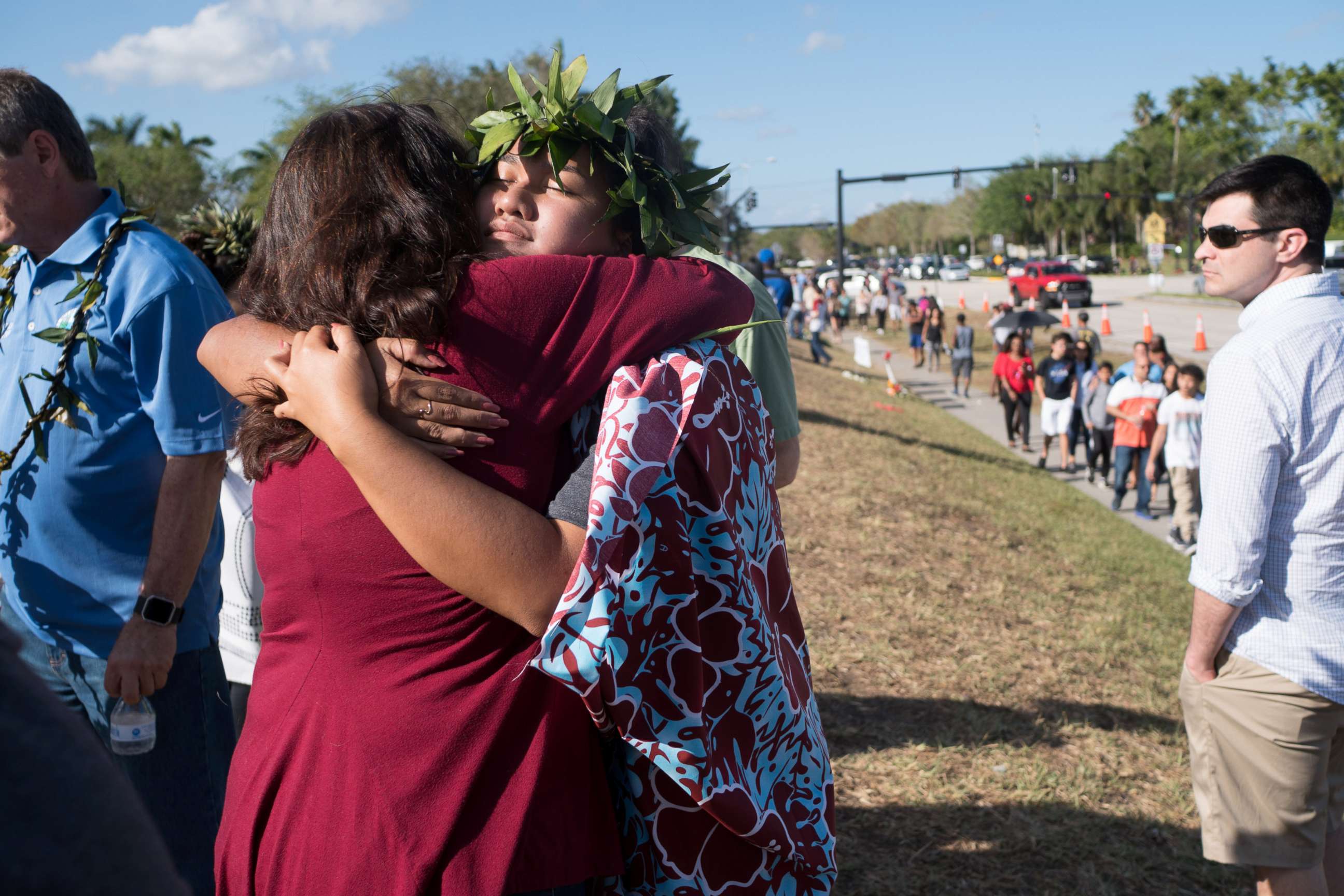 PHOTO: People embrace as students and parents arrive for voluntary campus orientation at the Marjory Stoneman Douglas High School, for the coming Wednesday's reopening, following last week's mass shooting in Parkland, Fla., Feb. 25, 2018.