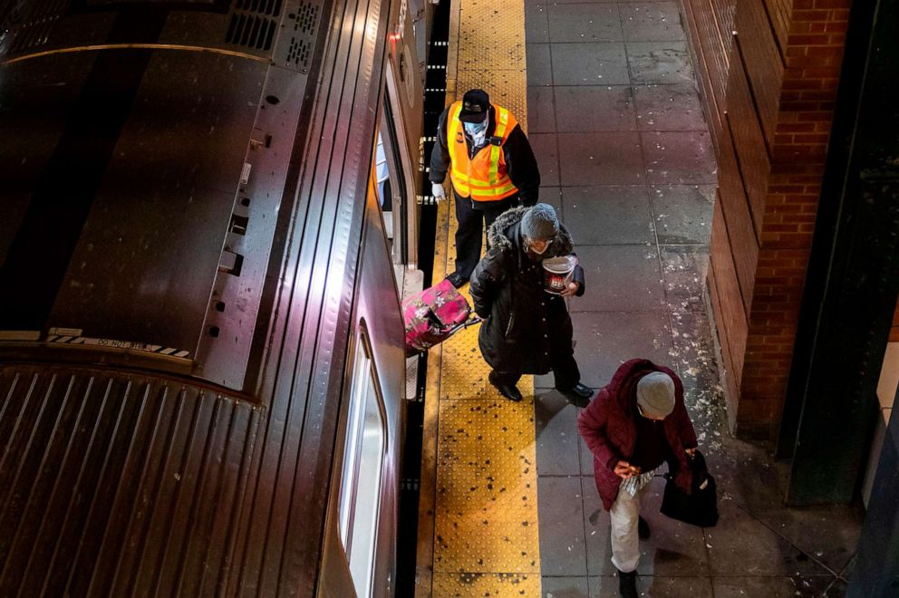 PHOTO: A transit worker clears subway cars of passengers at a station in Brooklyn, New York, May 6, 2020. The New York City subway system is being suspended between 1 AM and 5 AM so that trains may be cleaned to stop the spread of the coronavirus.