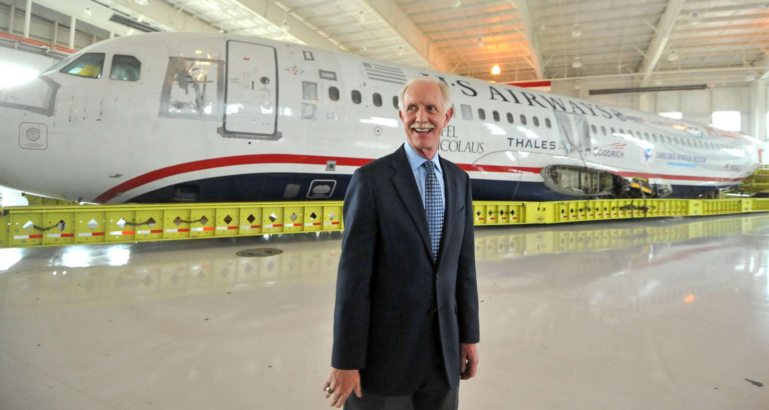PHOTO: Capt. Chesley Sullenberger, stands in front of the US Airways flight 1549 fuselage at the Carolinas Aviation Museum, June 11, 2011. 