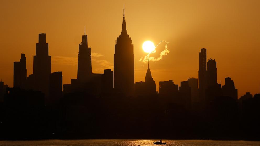 PHOTO: The sun rises behind the skyline of midtown Manhattan, the Chrysler Building and the Empire State Building on a day with an extreme heat warning in New York City, July 2, 2026.