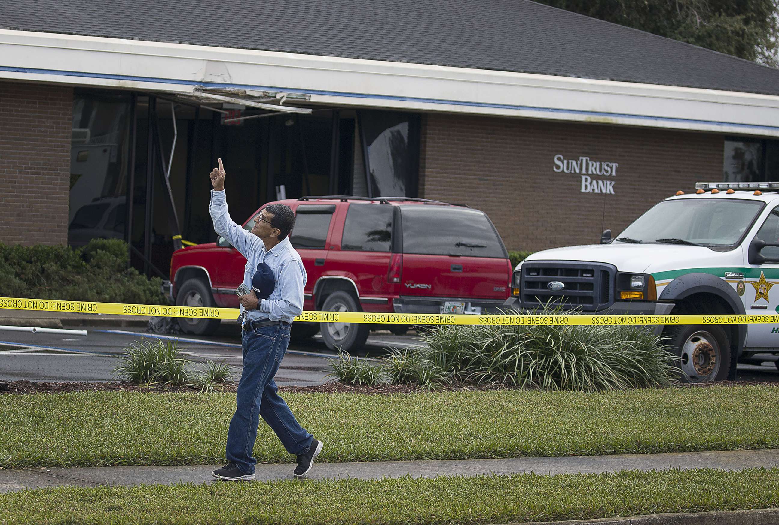 PHOTO: Jose Sanchez points to the sky as he walks in front of the SunTrust Bank branch where he said his friend was killed yesterday along with four other people on Jan. 24, 2019 in Sebring, Fla.