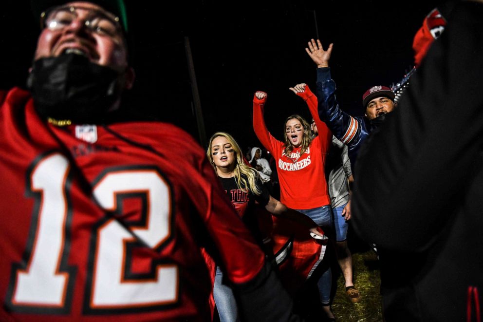 PHOTO: Tampa Bay Buccaneers fans celebrate their victory over the Kansas City Chiefs during Super Bowl LV in a parking lot near Raymond James Stadium in Tampa, Fla., Feb. 7, 2021.