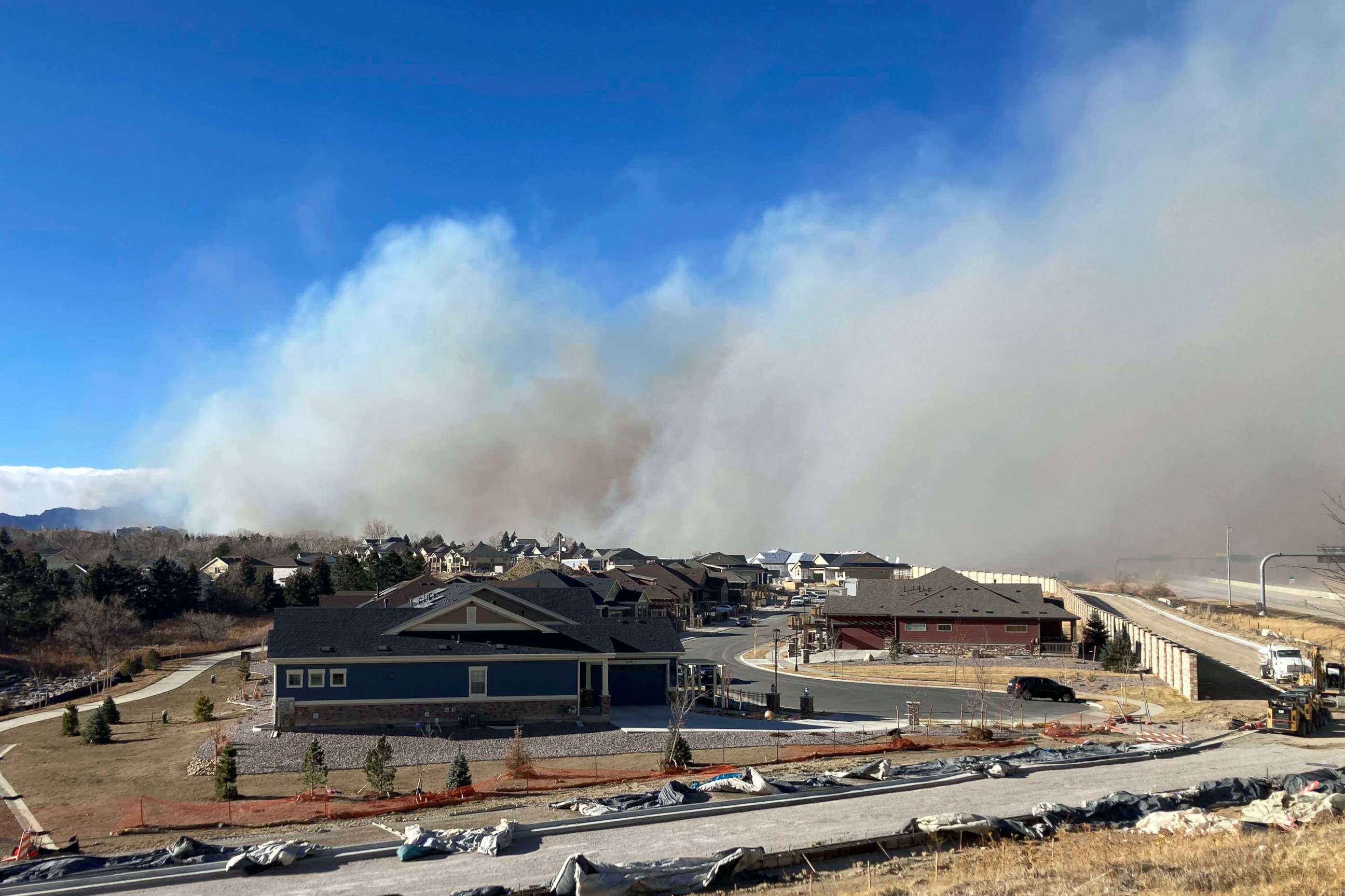 PHOTO: Smoke from a wildfire rises in the background, Thursday, Dec. 30, 2021, in Superior, Colo. All 13,000 residents of the northern Colorado town were ordered to evacuate Thursday because of a wildfire driven by strong winds.