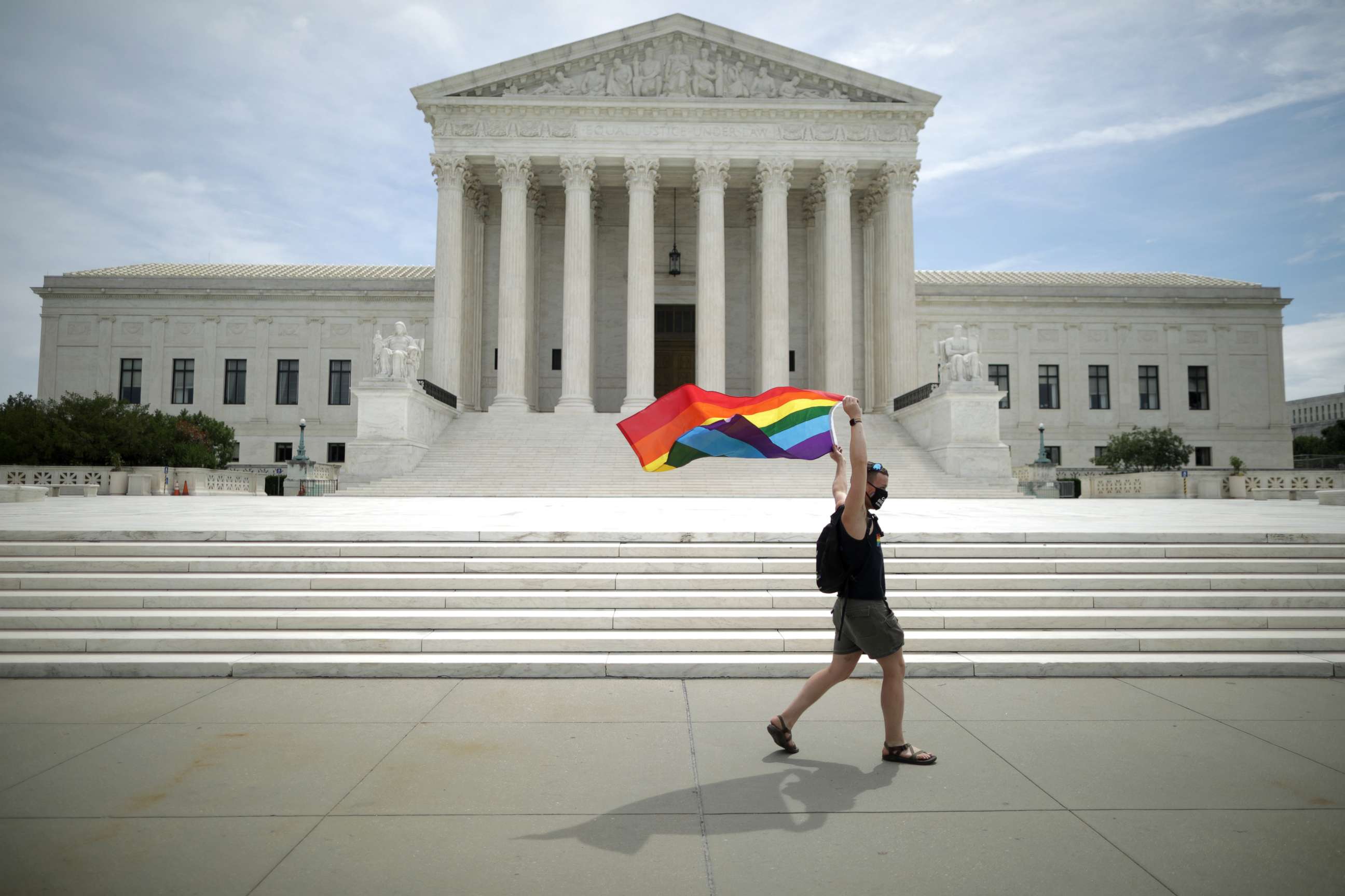PHOTO: Joseph Fons holds a Pride Flag as he walks back and forth in front of the U.S. Supreme Court building after the court ruled that LGBTQ people can not be disciplined or fired based on their sexual orientation, June 15, 2020 in Washington.