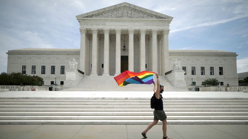 PHOTO: Joseph Fons holds a Pride Flag as he walks back and forth in front of the U.S. Supreme Court building after the court ruled that LGBTQ people can not be disciplined or fired based on their sexual orientation, June 15, 2020 in Washington.