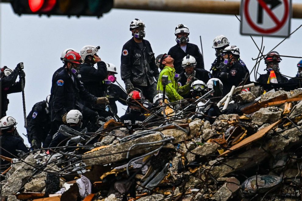 PHOTO: Search and rescue teams look for possible survivors in the partially collapsed 12-story Champlain Towers South condo building on June 30, 2021, in Surfside, Fla.