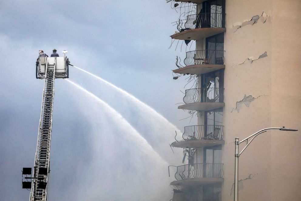 PHOTO: Miami-Dade Fire Rescue firefighters spray water from a crane to the debris of a partially collapsed building in Surfside, north of Miami Beach, on June 25, 2021.