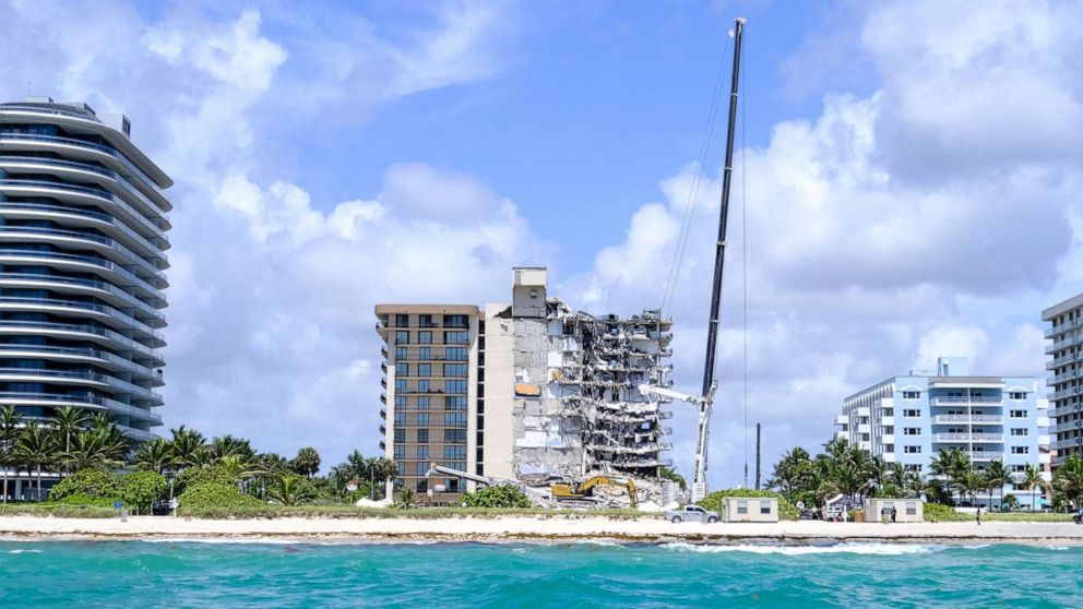 PHOTO: Heavy machinery works next to the partially collapsed residential building as search and rescue operations continue, in Surfside near Miami Beach, Fla., June 27, 2021.