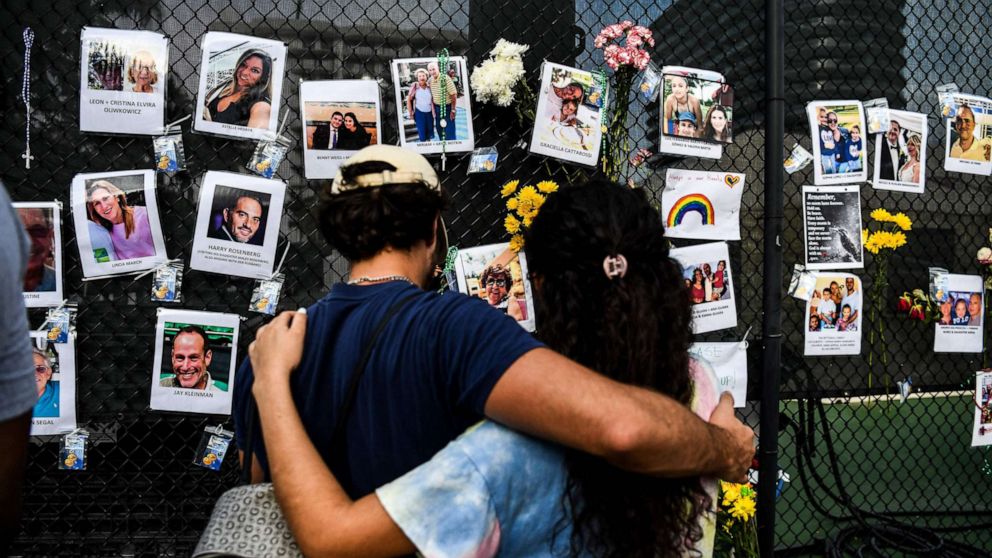 PHOTO: People visit the makeshift memorial for the victims of the building collapse, near the site of the accident in Surfside, Fla., June 27, 2021.