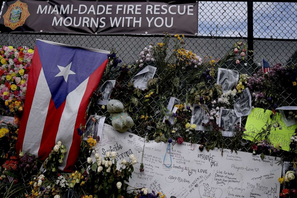 PHOTO: Signs and flowers hang on the memorial site of the collapsed 12-story Champlain Towers South condo building, July 10, 2021, in Surfside, Florida.