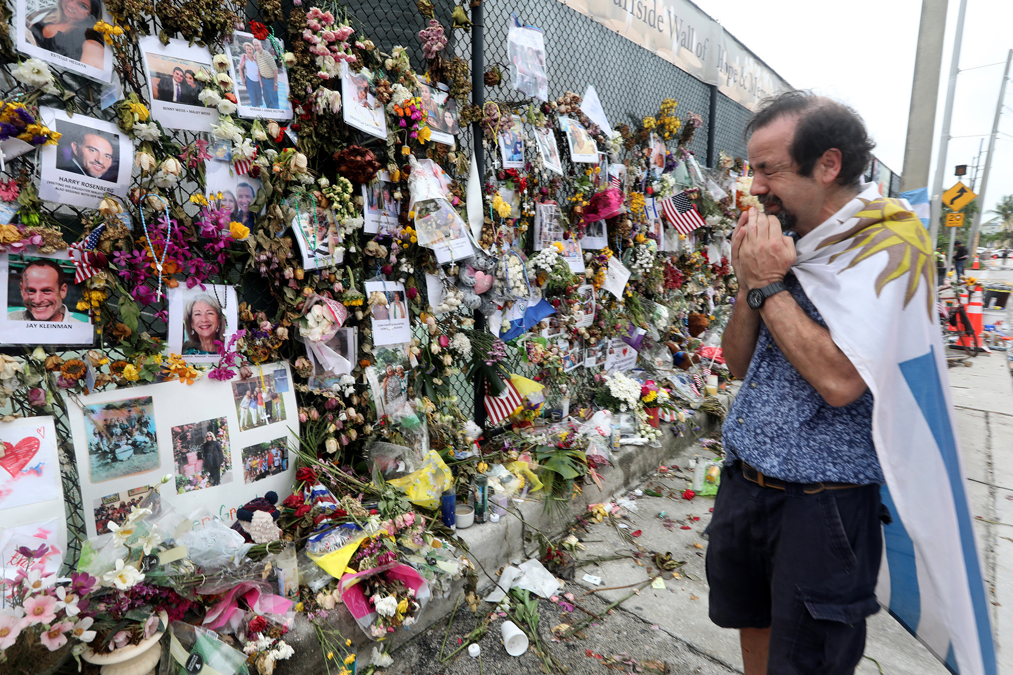 PHOTO: Bernardo Camou Fonte, 59, cries as he prays at the memorial wall in front of the site of the Champlain Towers South condo collapse in Surfside, Florida, July 6, 2021.