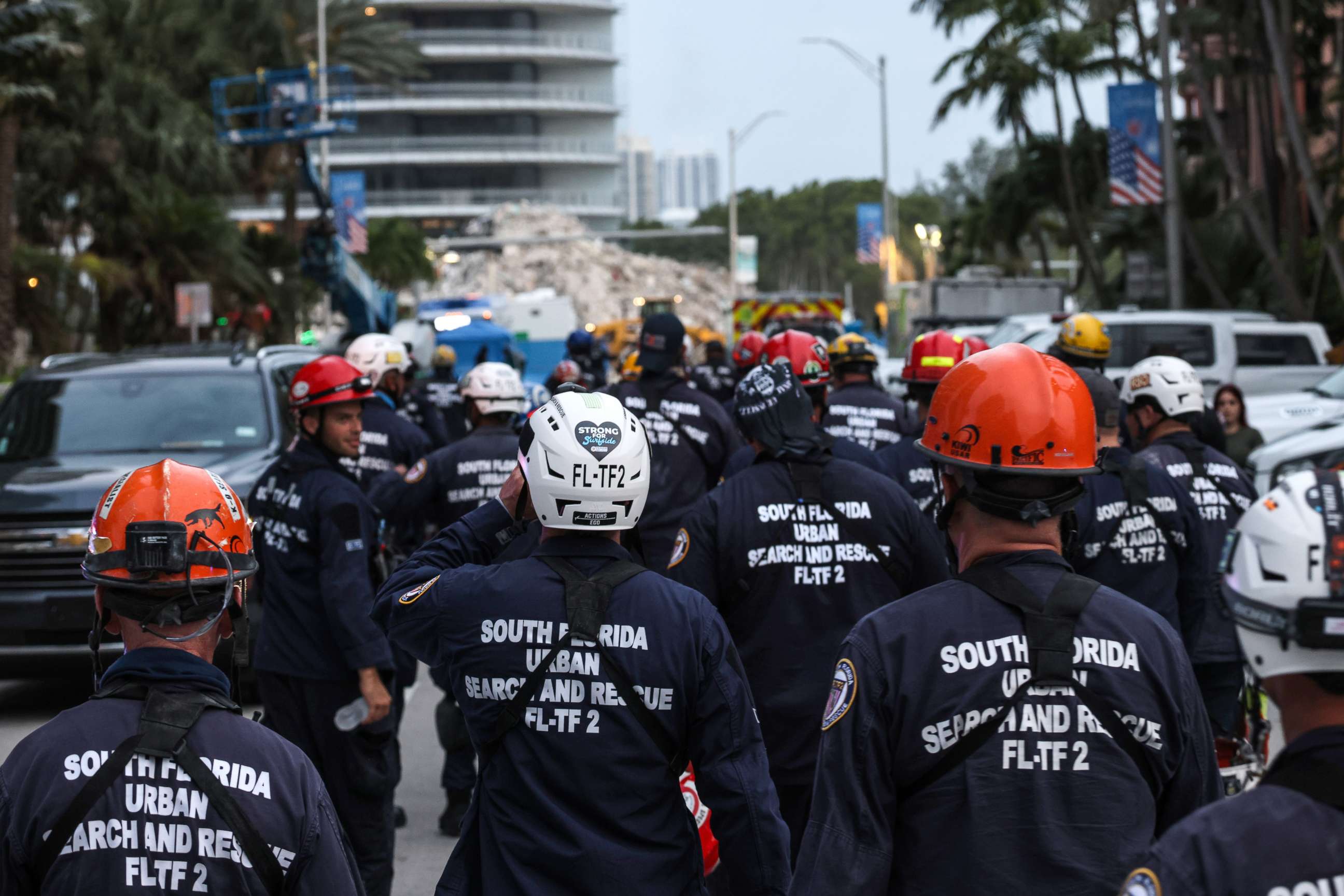 PHOTO: Rescue personnel walk back to work on the recovery operation at the collapsed 12-story Champlain Towers South condo building after a send off for members of the Israel Defense Forces National Rescue Unit, July 10, 2021, in Surfside, Florida.