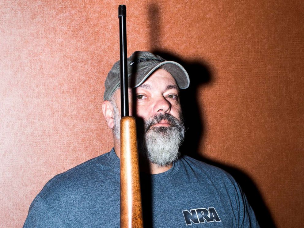 PHOTO: Chuck Cook holds a gun as he poses.
