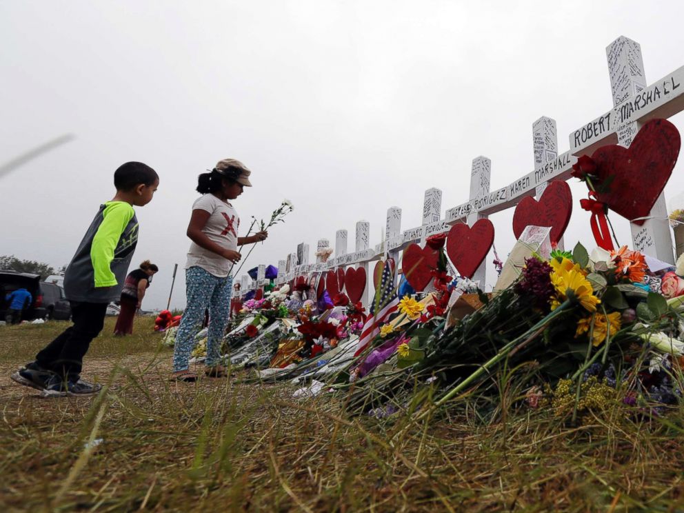 PHOTO: Alexander Osborn and Bella Araiza leave flowers at a makeshift memorial for the victims of the shooting at Sutherland Springs Baptist Church, Nov. 12, 2017, in Sutherland Springs, Texas.