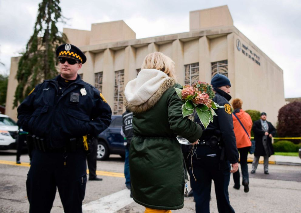 PHOTO: A woman brings flowers to a memorial, Oct. 28, 2018, near the Tree of Life synagogue after a shooting there left 11 people dead in Pittsburgh, Oct. 27, 2018. 