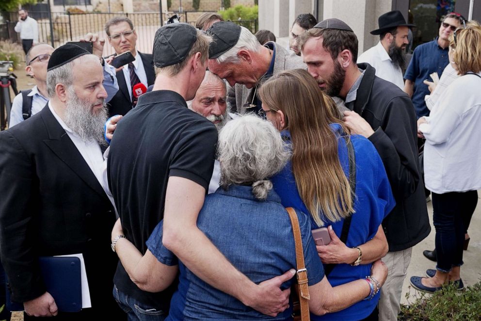 PHOTO: Executive Director Rabbi Yisroel Goldstein, center, hugs his congregants after a press conference outside the Chabad of Poway Synagogue, April 28, 2019 in Poway, Calif.