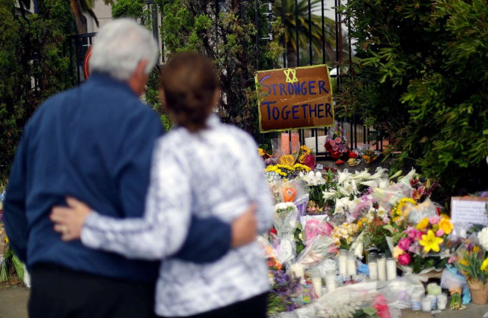 A couple embrace near a growing memorial across the street from the Chabad of Poway synagogue in Poway, Calif., on Monday, April 29, 2019.