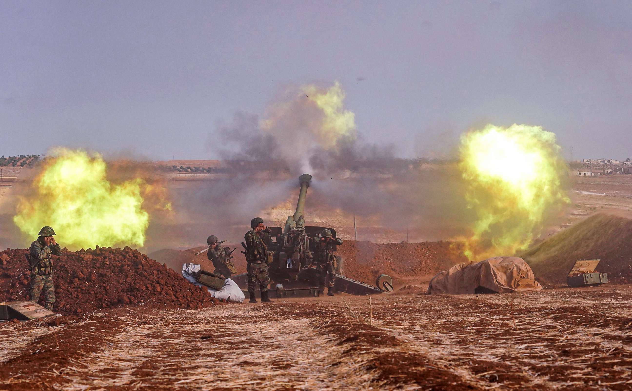 PHOTO: A handout picture released by the official Syrian Arab News Agency (SANA), Oct. 22, 2019 shows Syrian army artillery guns firing from a position in al-Habit on the southern edges of the Idlib province. 