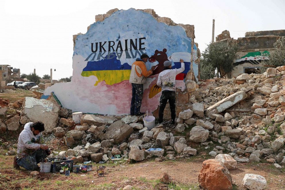 PHOTO: Syrian artists Aziz Asmar and Anis Hamdoun paint a mural to protest against Russia's military operation in Ukraine, in the rebel-held town of Binnish in Syria's northwestern Idlib province, on Feb. 24, 2022.