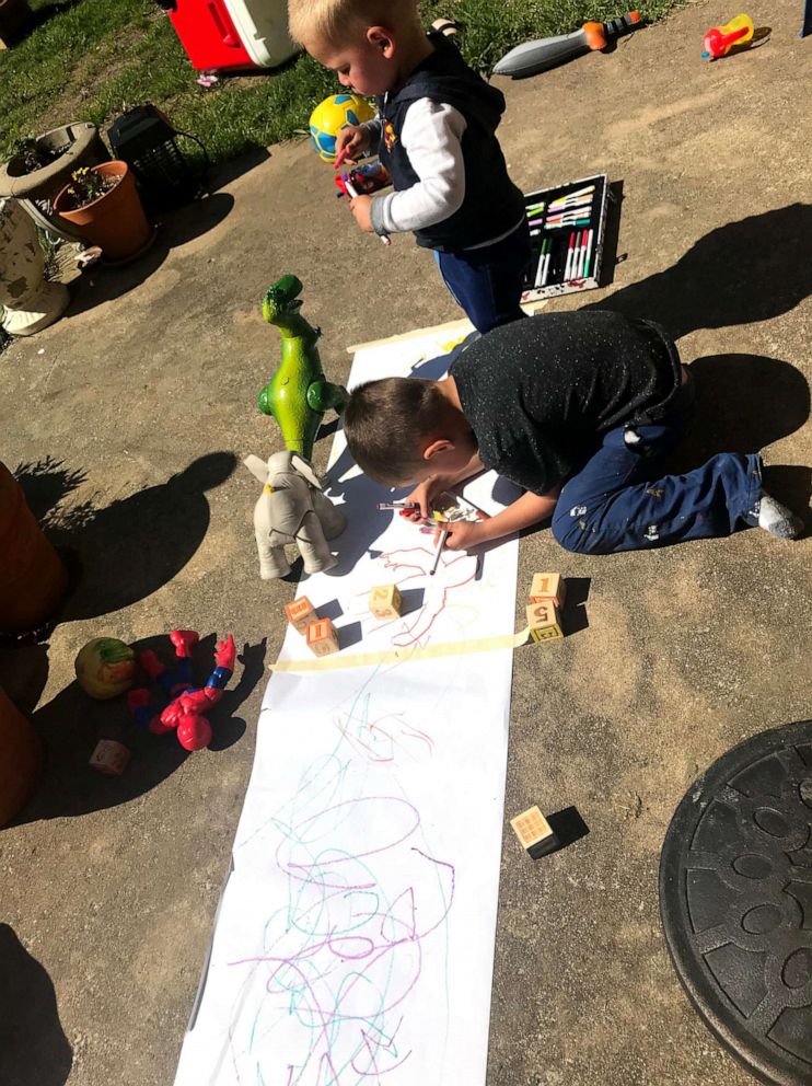 PHOTO: Kristine Tague's young sons work on art projects outside. 