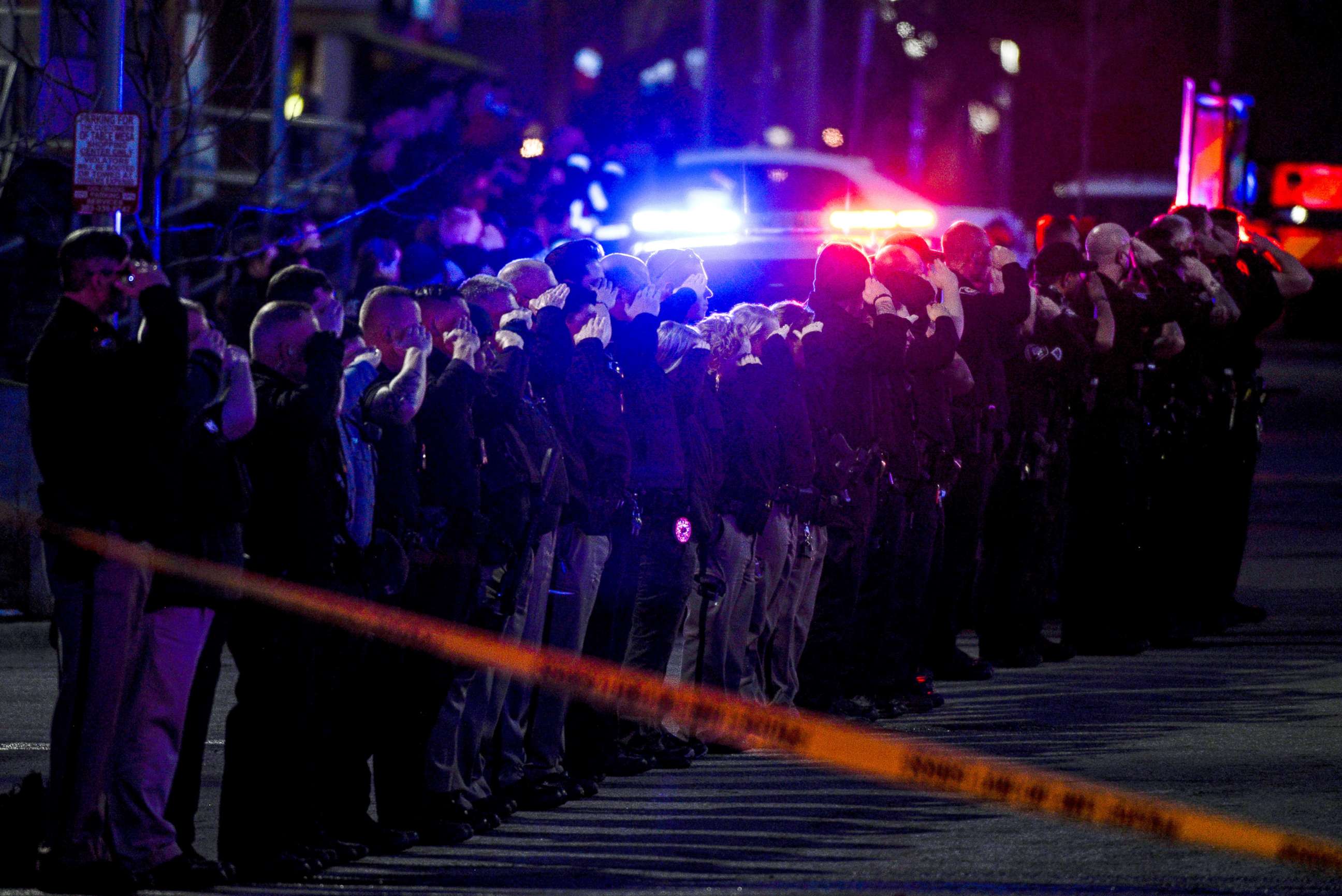 PHOTO: Law enforcement officers salute as emergency vehicles escort the body of slain police officer Eric Talley from the scene of a shooting at a King Soopers grocery store in Boulder, Colo., March 22. 2021.