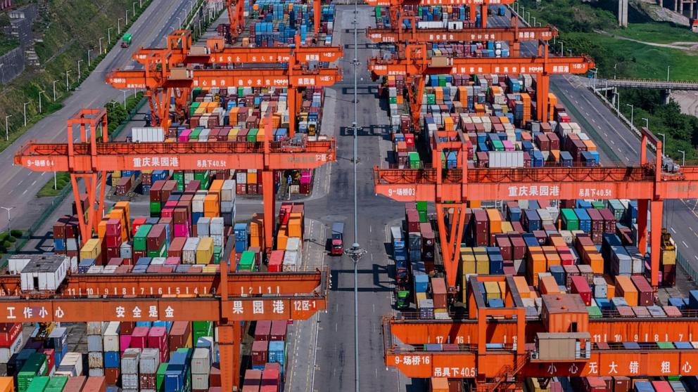 PHOTO: Trucks move past piles of containers stacked at a container terminal port on the Yangtze River in southwest China's Chongqing Municipality, April 20, 2025.