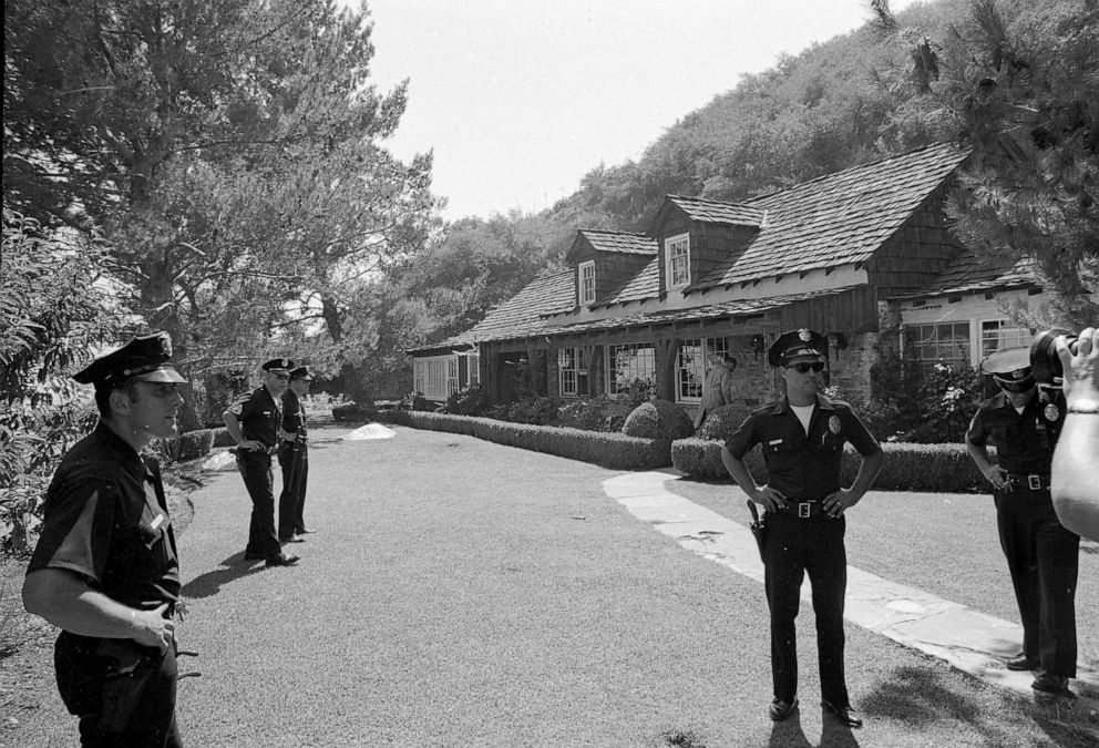 PHOTO: Police officers stand on the property of actress Sharon Tate where the bodies of five persons, including Tate, were found murdered by members of the Manson cult family, Aug. 9, 1969.