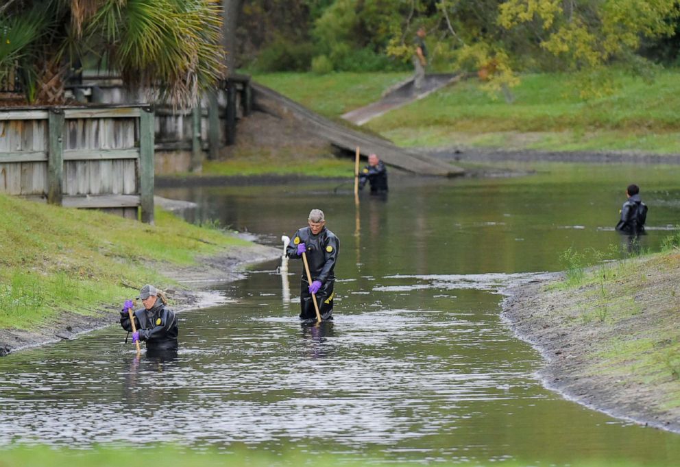 PHOTO: Law enforcement investigators in dry suits search the small retention pond near the entrance of the Southside Villas apartment complex off Southside Blvd. in Jacksonville, Fla., Nov. 6, 2019.