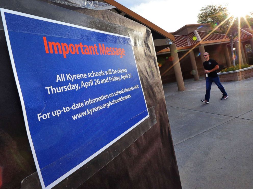 PHOTO: The sun rises over Kyrene De Las Lomas Elementary School, April 26, 2018, in Phoenix, as a teacher arrives.