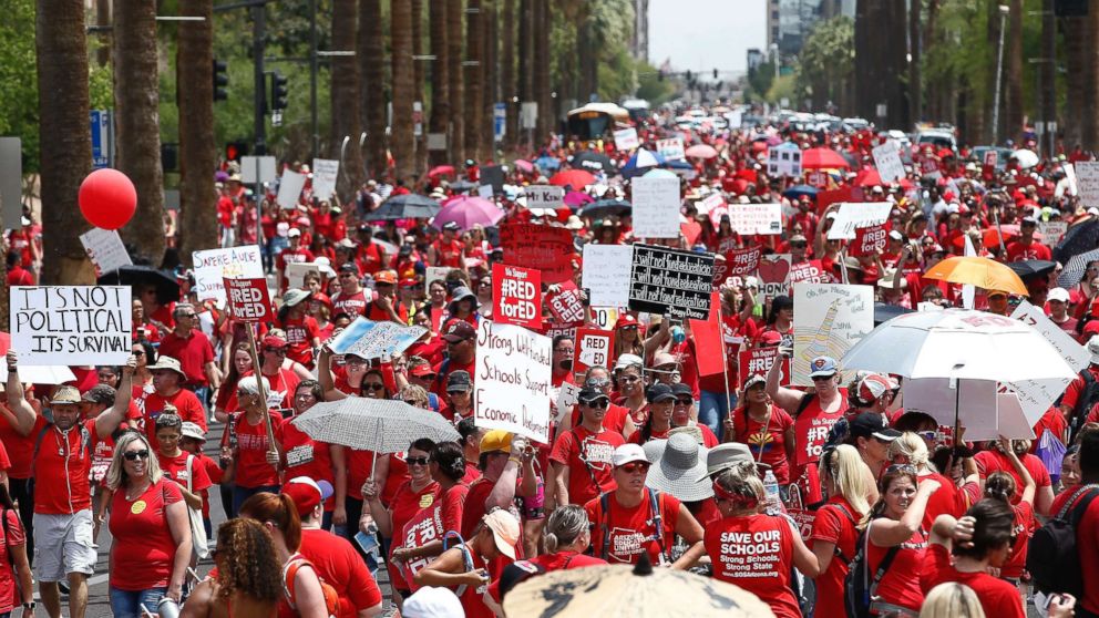 PHOTO: Thousands march to the Arizona Capitol for higher teacher pay and school funding on the first day of a state-wide teacher strike, April 26, 2018, in Phoenix.
