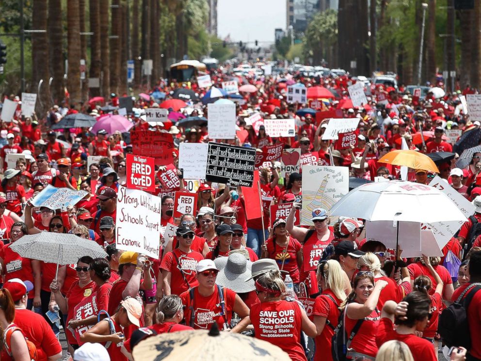 PHOTO: Thousands march to the Arizona Capitol for higher teacher pay and school funding on the first day of a state-wide teacher strike, April 26, 2018, in Phoenix.