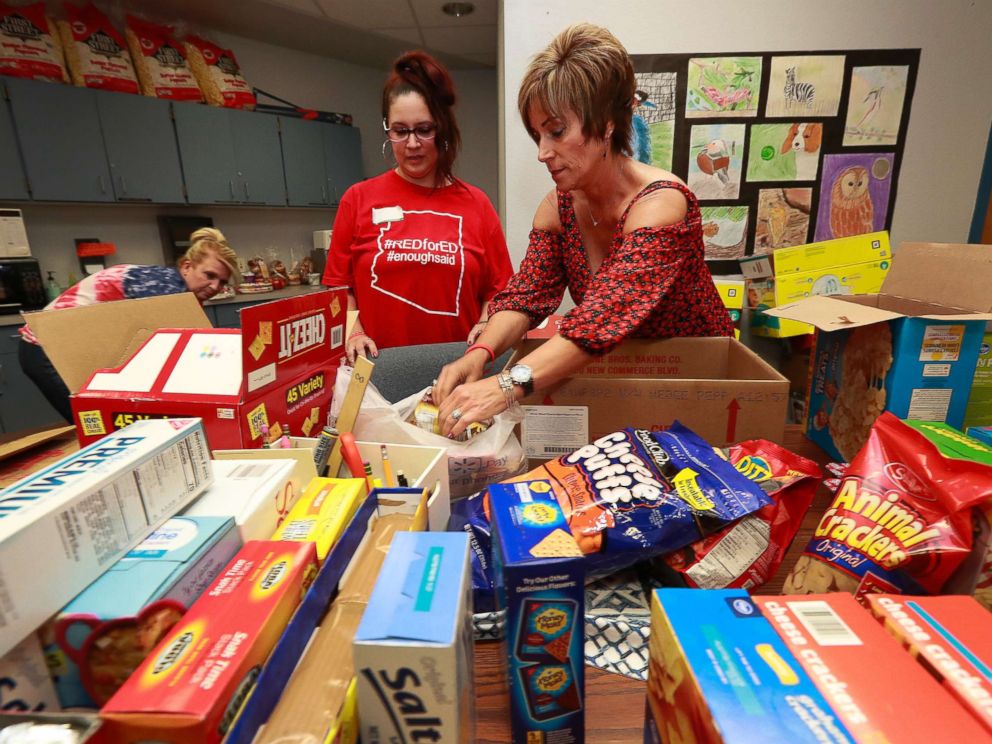 PHOTO: Highland Arts Elementary School teacher Amy Lahavich, right, organizes donated food for distribution to students and families on the eve of the teacher walk out, April 25, 2018, in Mesa, Ariz.