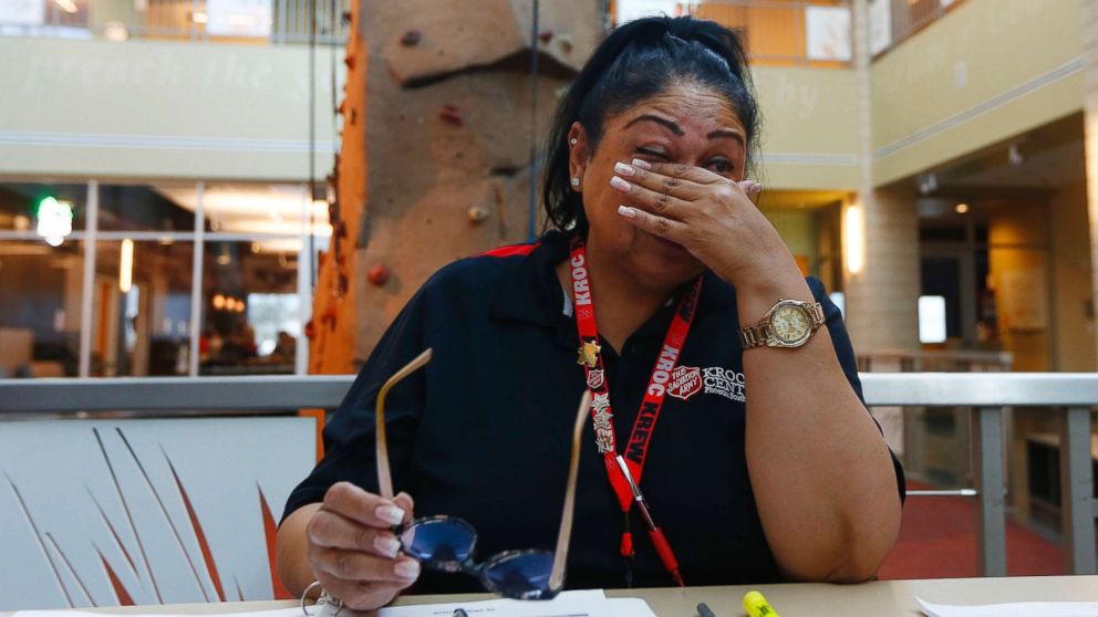PHOTO: Special education teacher Charmaine Woods wipes away tears as she talks about not being at her teaching job in the Roosevelt School District as she checks kids in at a special day camp at the Salvation Army Kroc Center, April 26, 2018, in Phoenix.