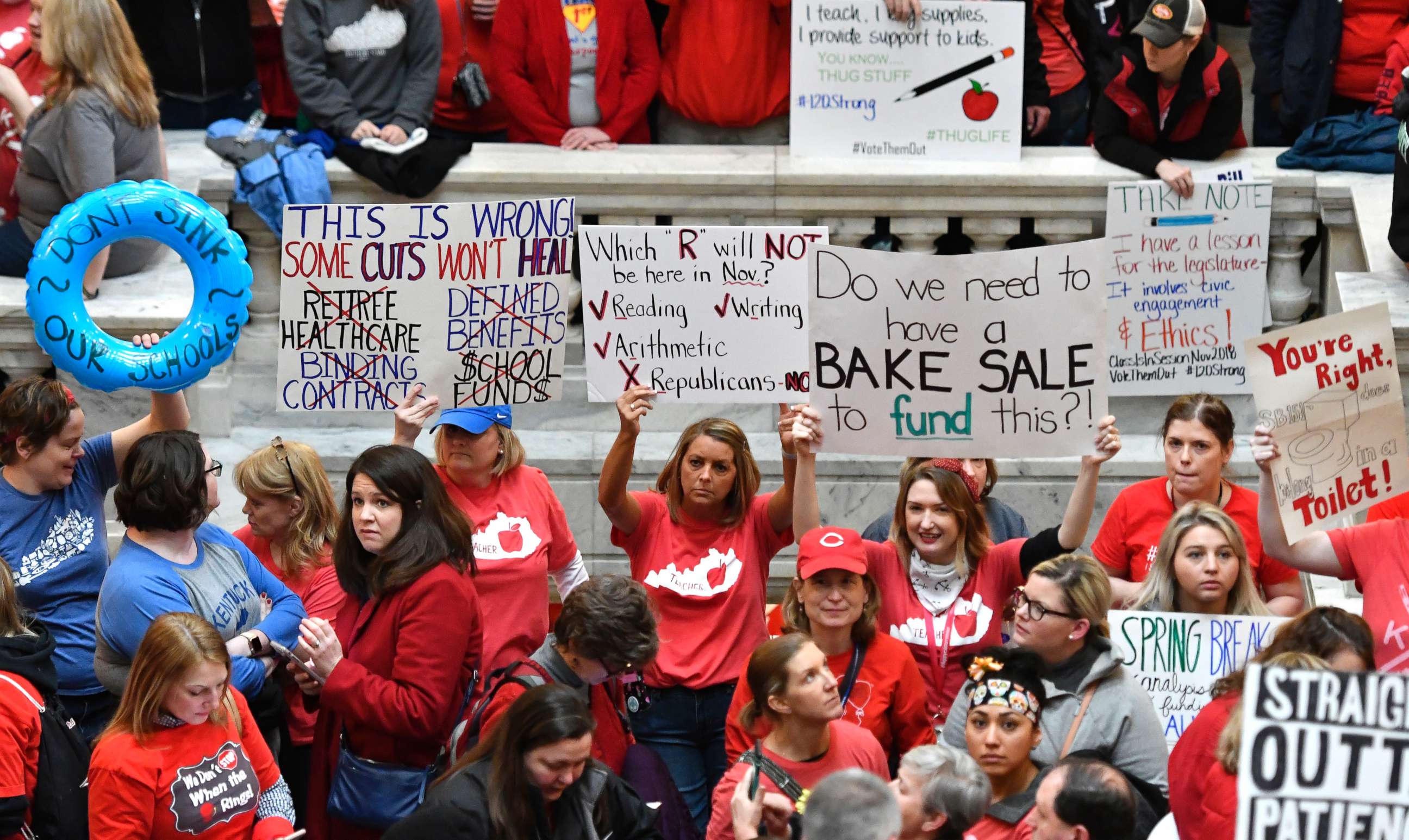 PHOTO: Teachers from across Kentucky hold up signs as they fill the state Capitol to rally for increased funding and to protest last minute changes to their state funded pension system, April 2, 2018, in Frankfort, Ky.